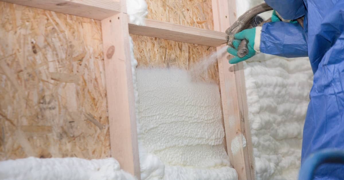 Professional technician installing spray foam insulation inside a wall cavity | REenergizeCO